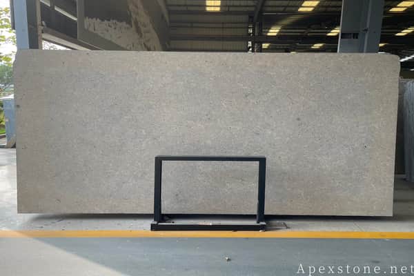 Warm grey limestone slab surface with fossil detail, cut for coping and landscape profiles