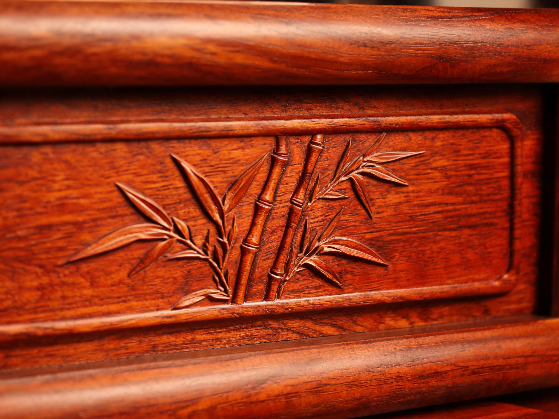 Close-up of the hand-carved bamboo motif in shallow relief on the apron of this solid Siamese rosewood tea table