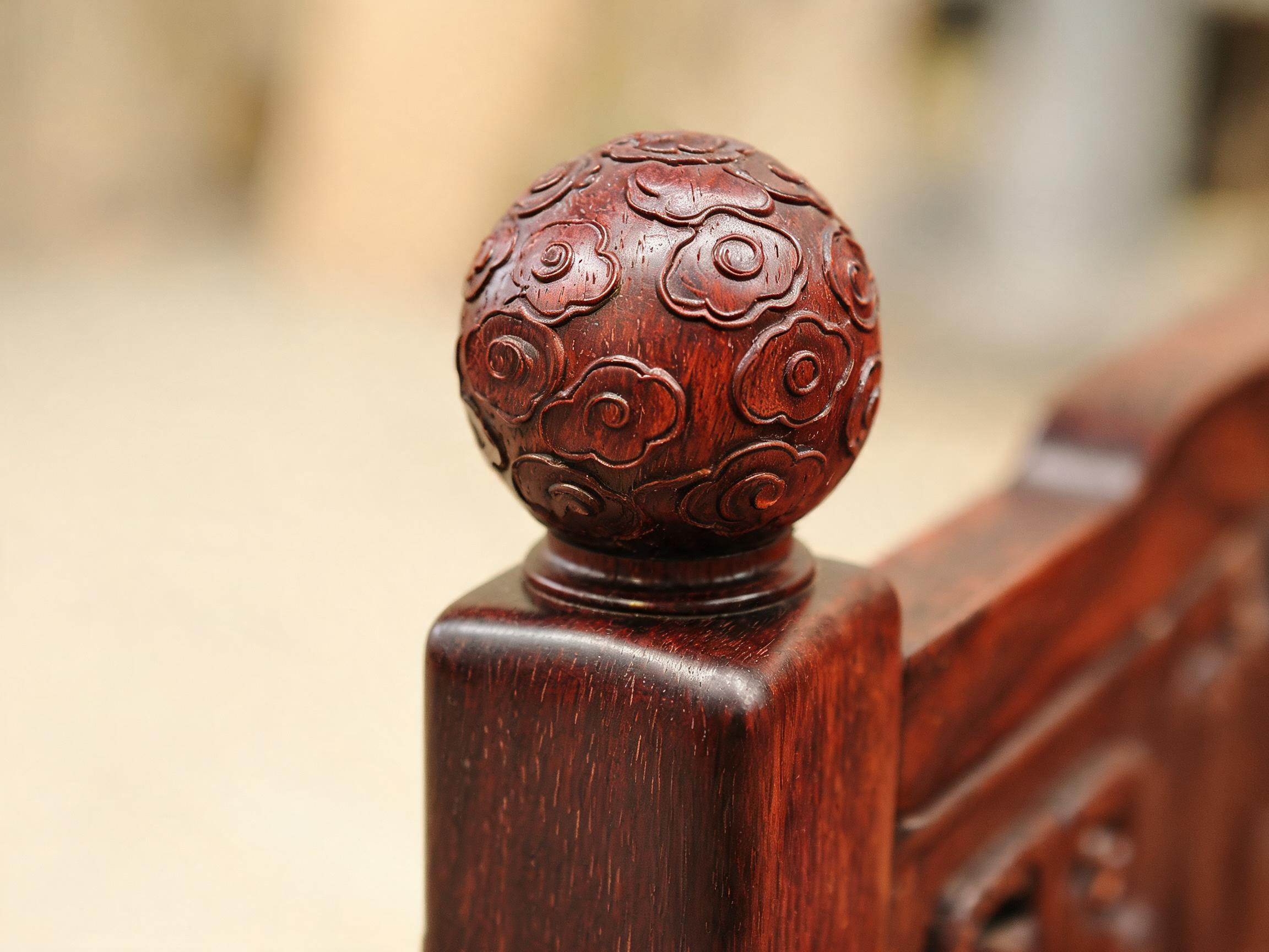 Hand-carved cloud-relief ball finial atop a solid rosewood canopy bed post
