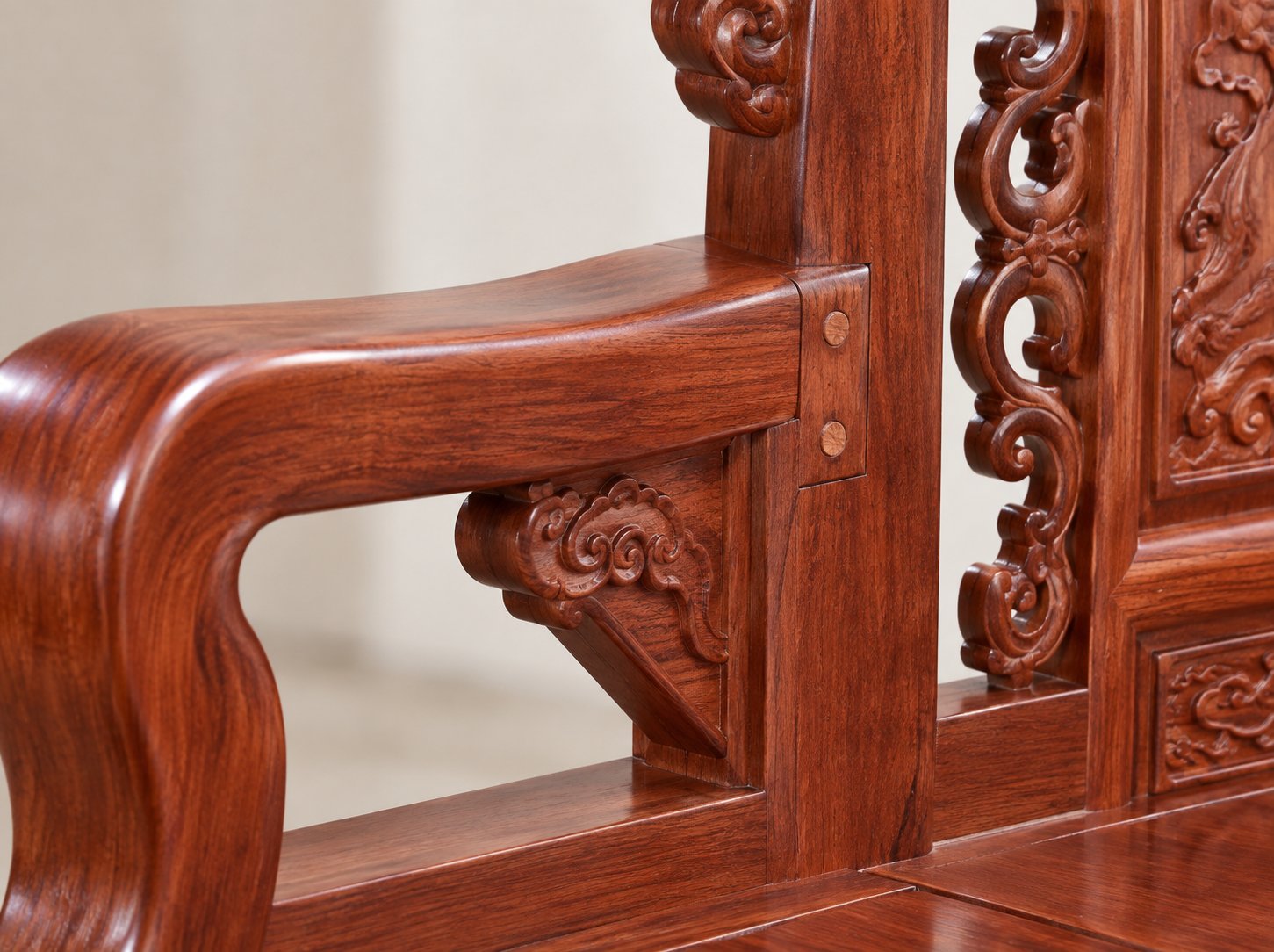 Close-up of the rosewood sofa armrest and backrest stile joint, showing the mortise-and-tenon connection and solid wood corner block