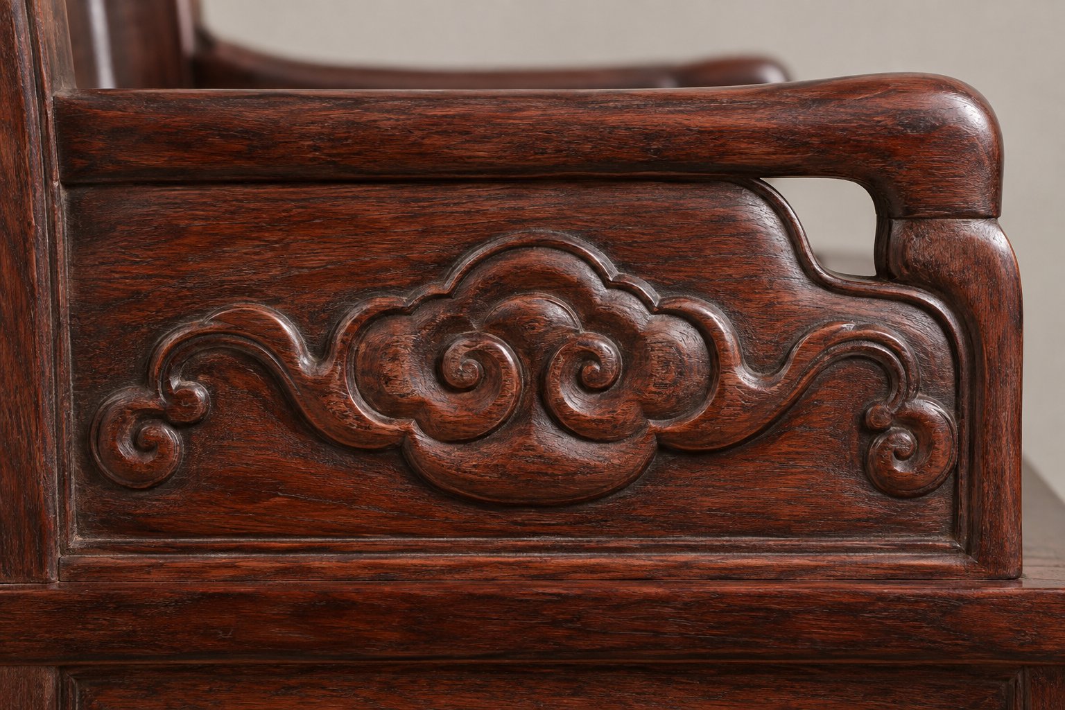 Ruyi cloud head relief carving on the armrest panel of a Siamese rosewood sofa