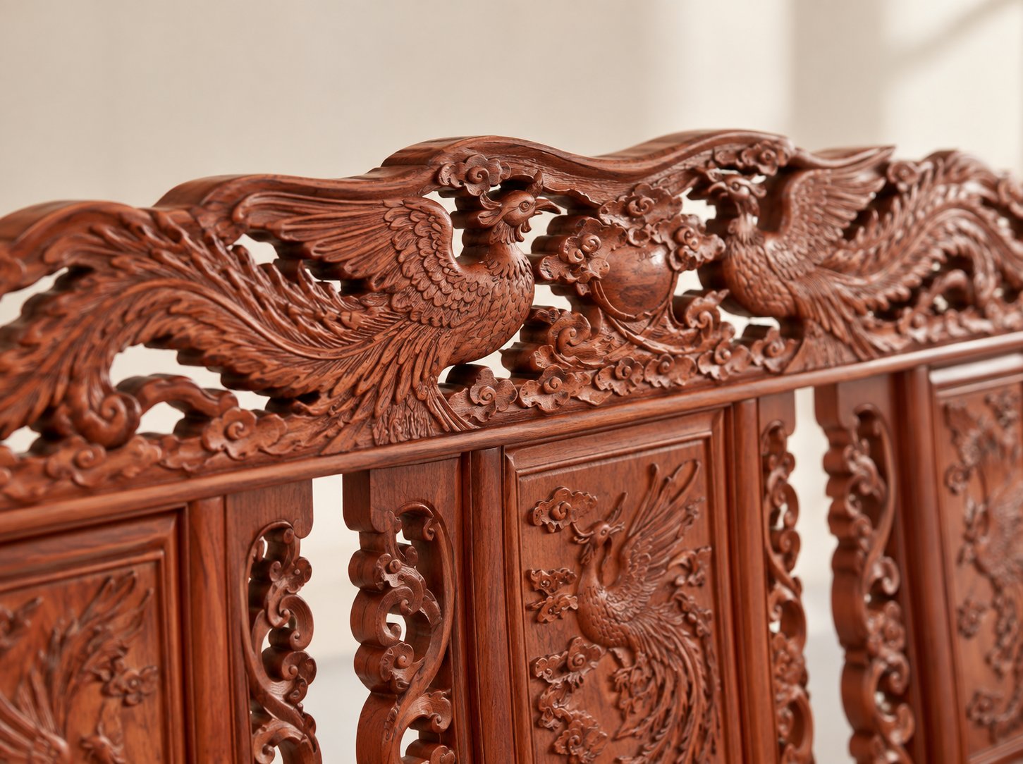 Close-up of the hand-carved phoenix relief on the rosewood sofa backrest, showing multi-layer carving depth and chisel marks