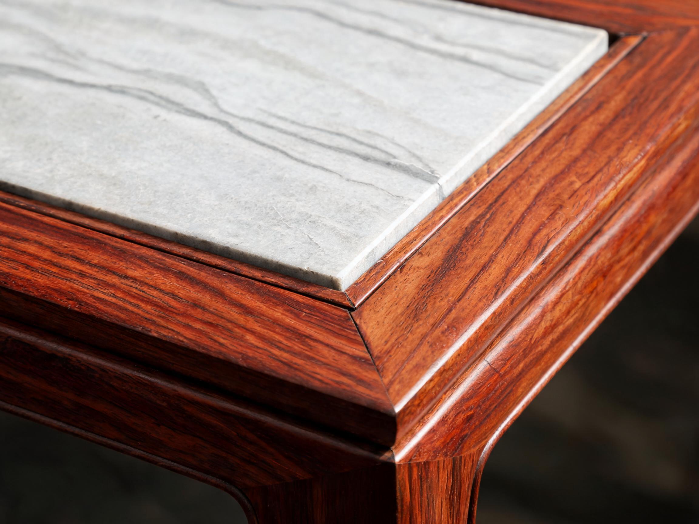 Close-up of the natural grey-veined stone panel seated in the recessed groove of the solid Siamese rosewood frame