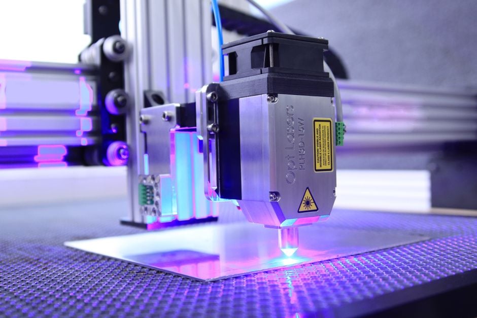 Laser head directing a blue beam onto a sheet