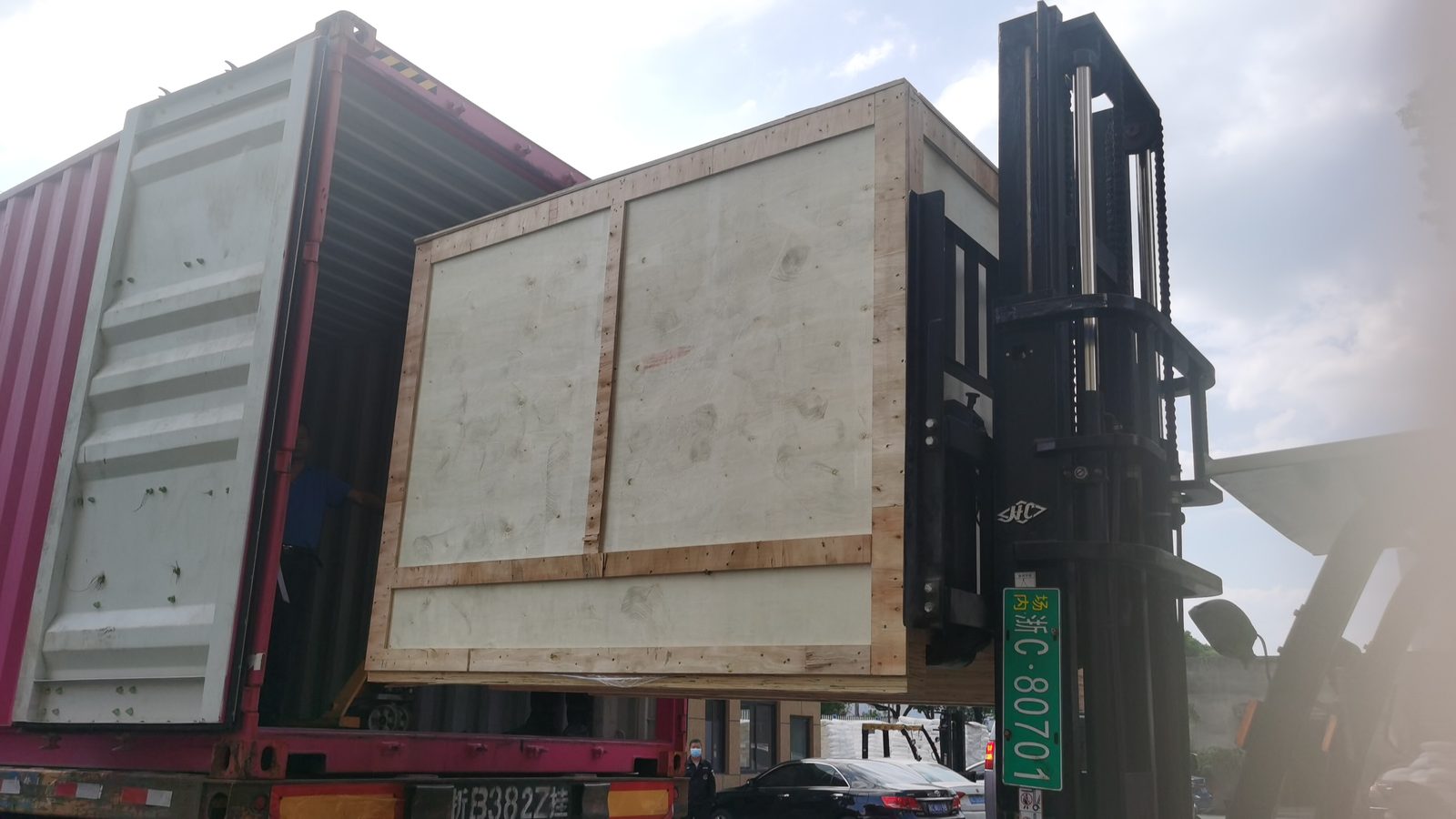 Packed machine in a wooden case being loaded for shipment