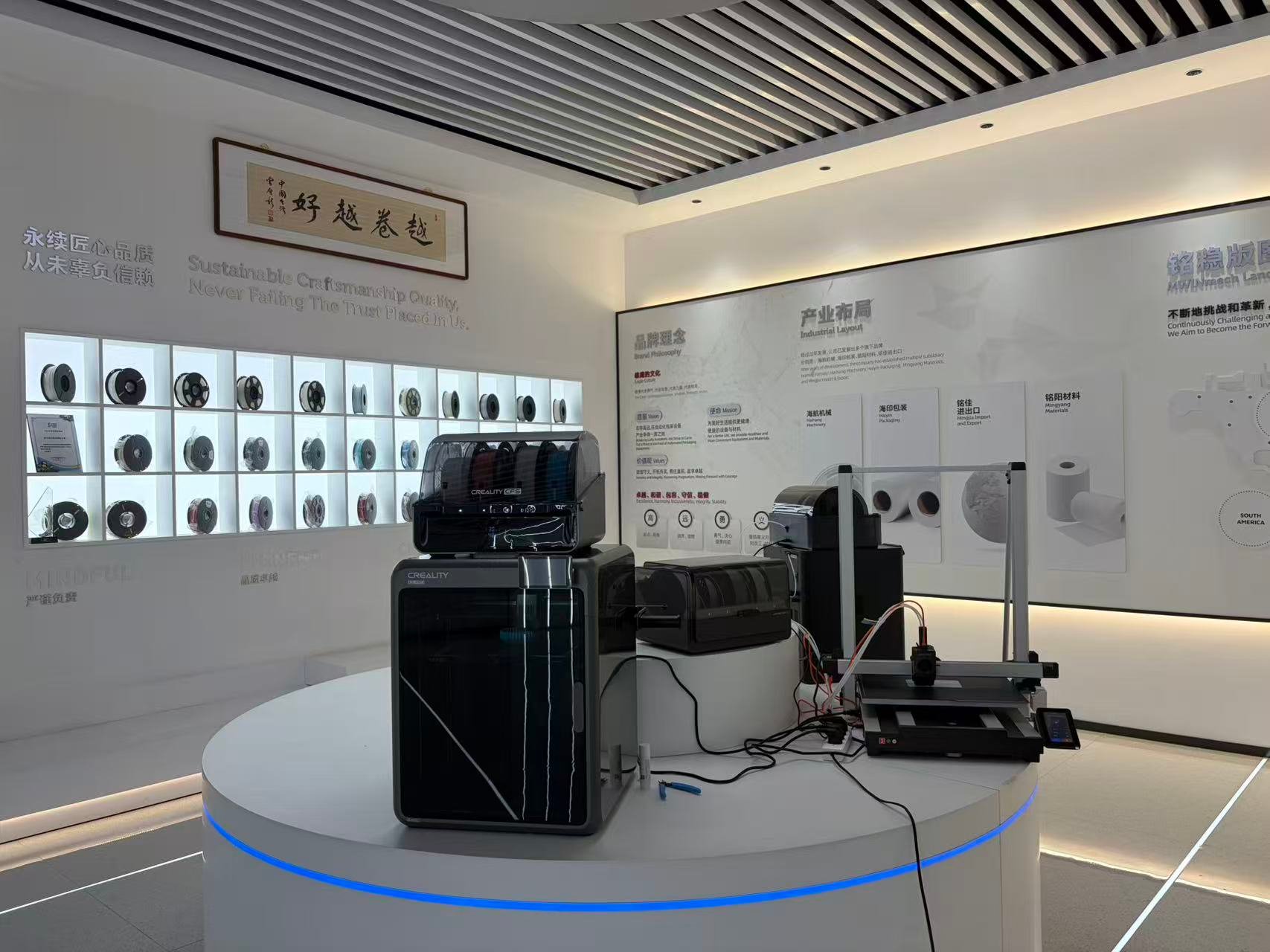 Showroom displaying 3D printers, filament spools and the company brand wall