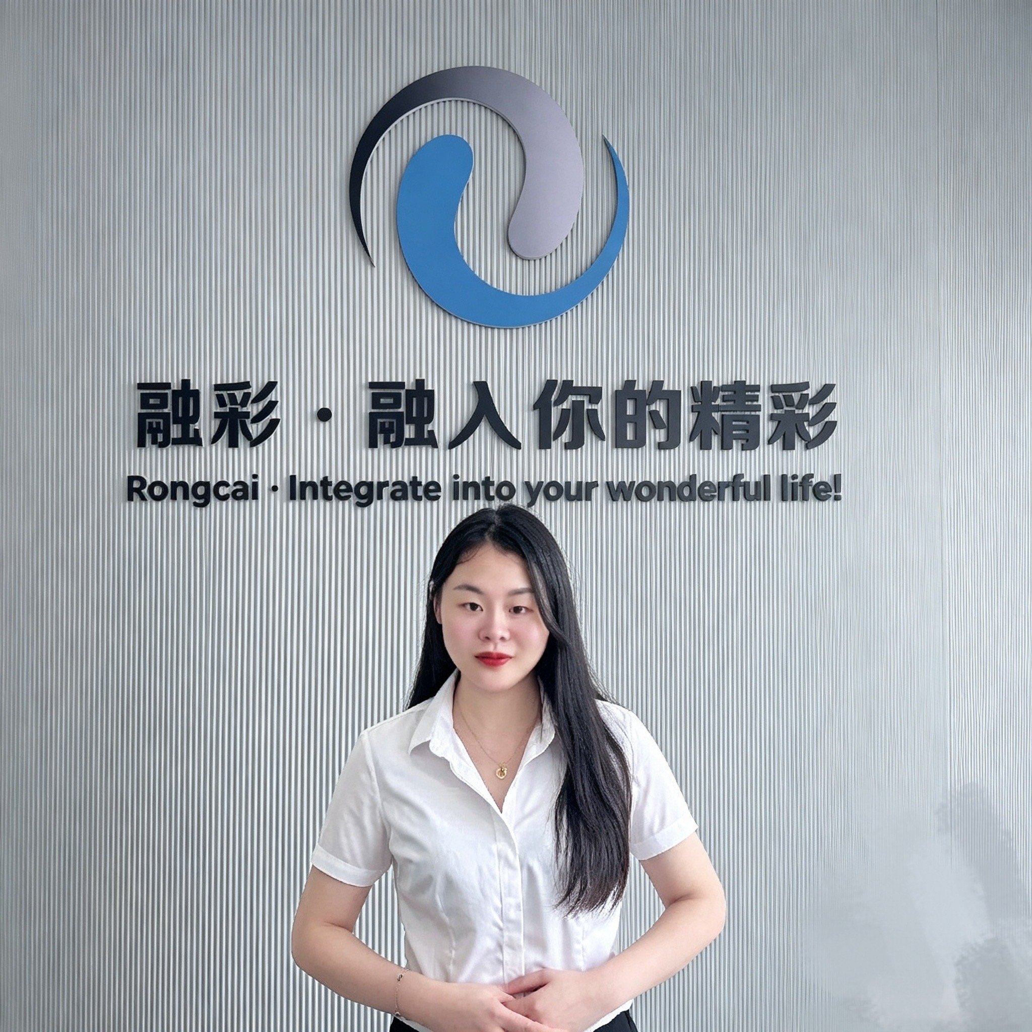 Abby, sales contact at Zhejiang Rongcai Machinery, in front of the Rongcai brand wall