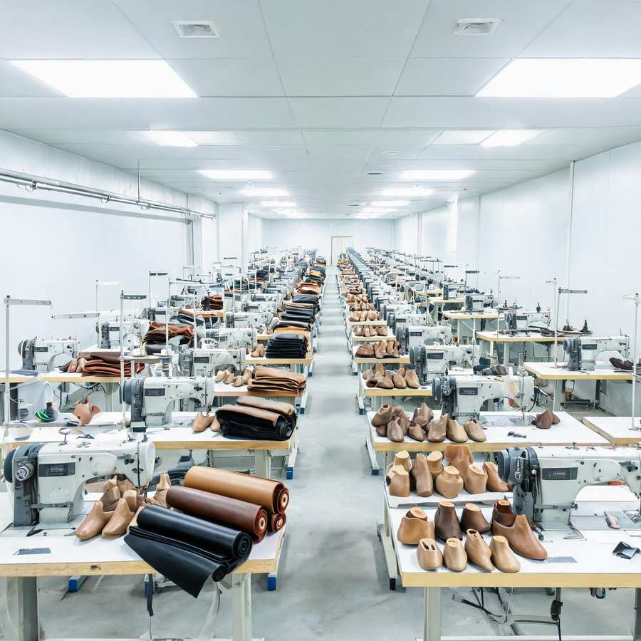 Footwear production workshop with cutting, stitching and lasting lines for leather sneaker manufacturing